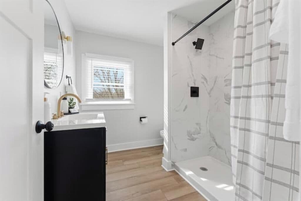 Une salle de bain moderne avec une douche, un lavabo et un miroir.