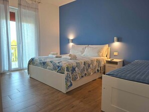 A bedroom with a bed, a nightstand, a dresser, and a window with curtains. - Ricomincio da Polignano (Polignano a Mare)