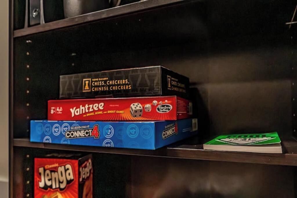 A shelf with board games including Chess, Checkers, and Connect 4.