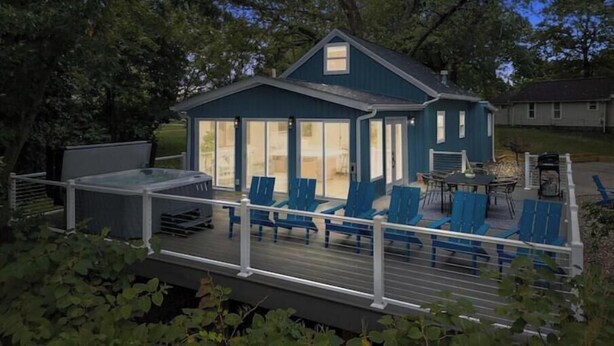 Una casa con terraza, mobiliario exterior y un jacuzzi.