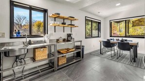 Una cucina moderna con piano cottura integrato, lavello e zona pranzo con tavolo e sedie.