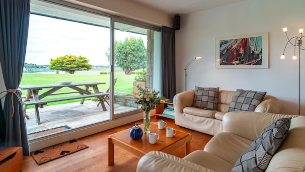 Un salon avec un canapé, une table basse et un tableau accroché au mur.