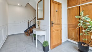 A staircase with a white wall and a wooden door.