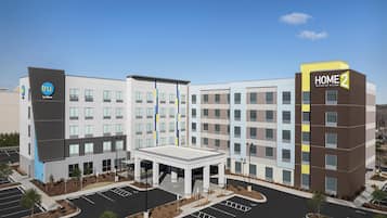 A modern hotel with a central courtyard, multiple floors, and a prominent 'HOME 2' sign.
