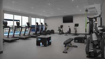 A modern gym with treadmills, stationary bikes, and weight equipment.