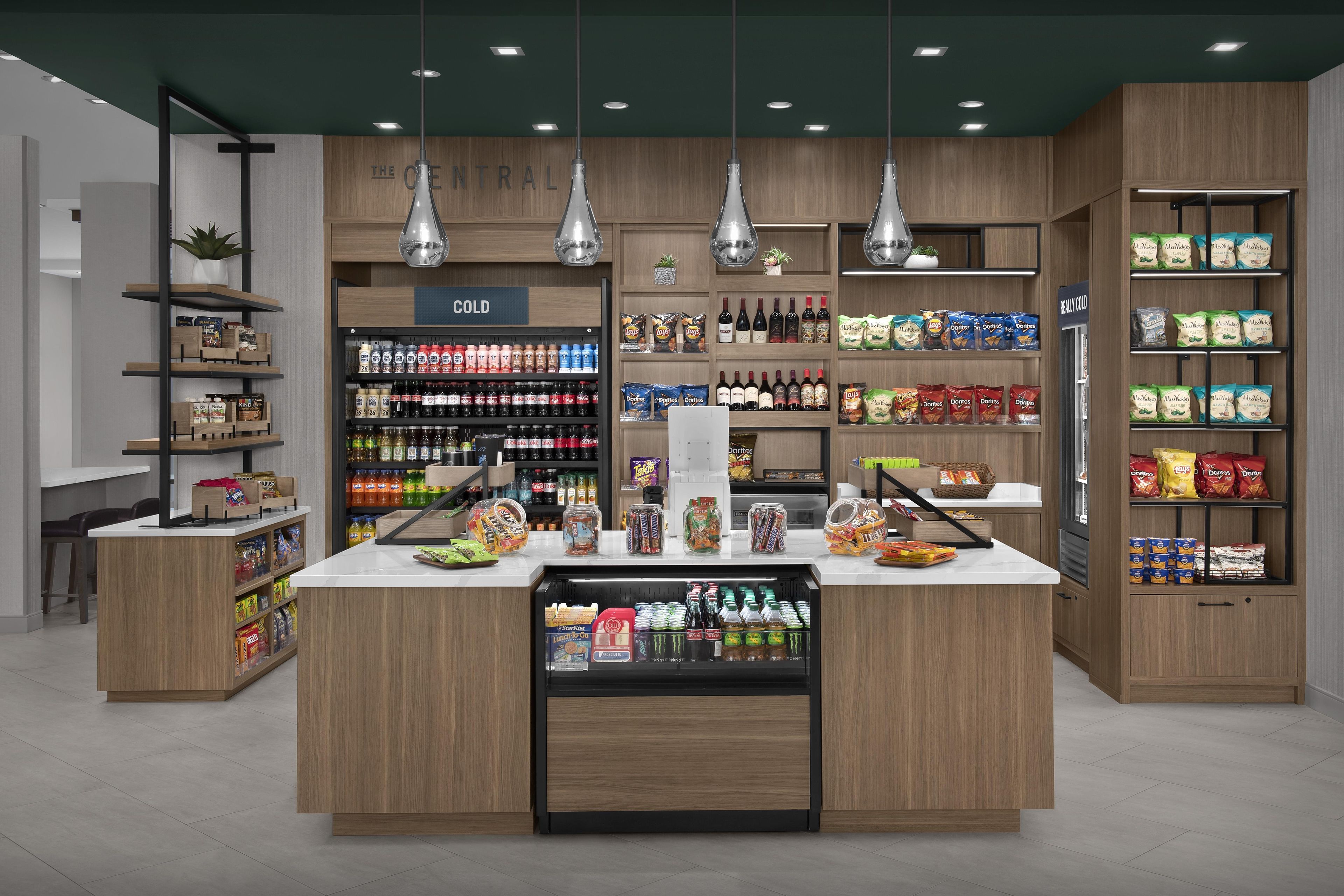 Un supermercado moderno con estanterías de madera, áreas de refrigeración y una gran variedad de aperitivos y bebidas.