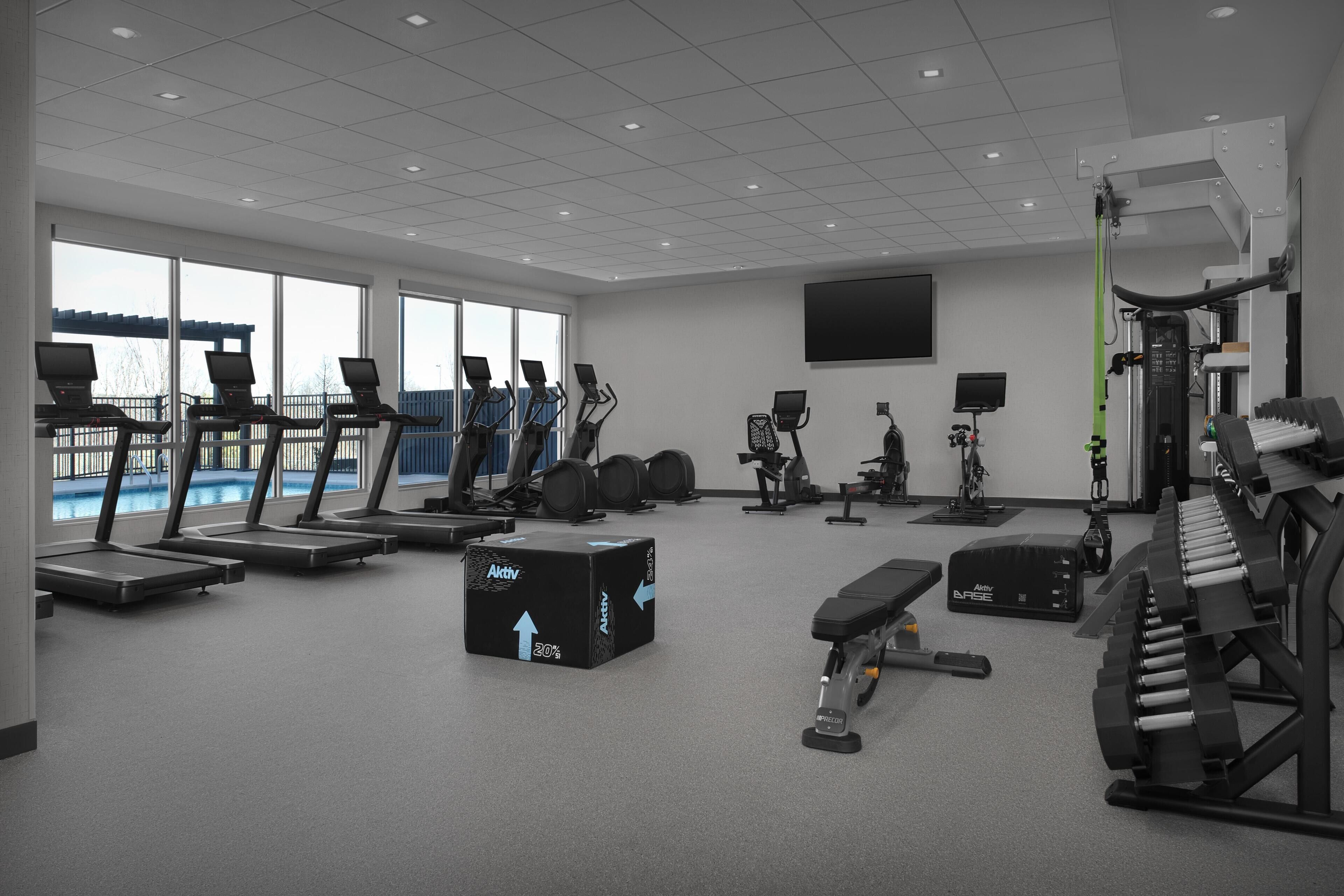 A gym with treadmills, stationary bikes, and weightlifting equipment.