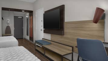 A hotel room with a bed, a desk with a chair, a TV mounted on the wall, and a shower area.