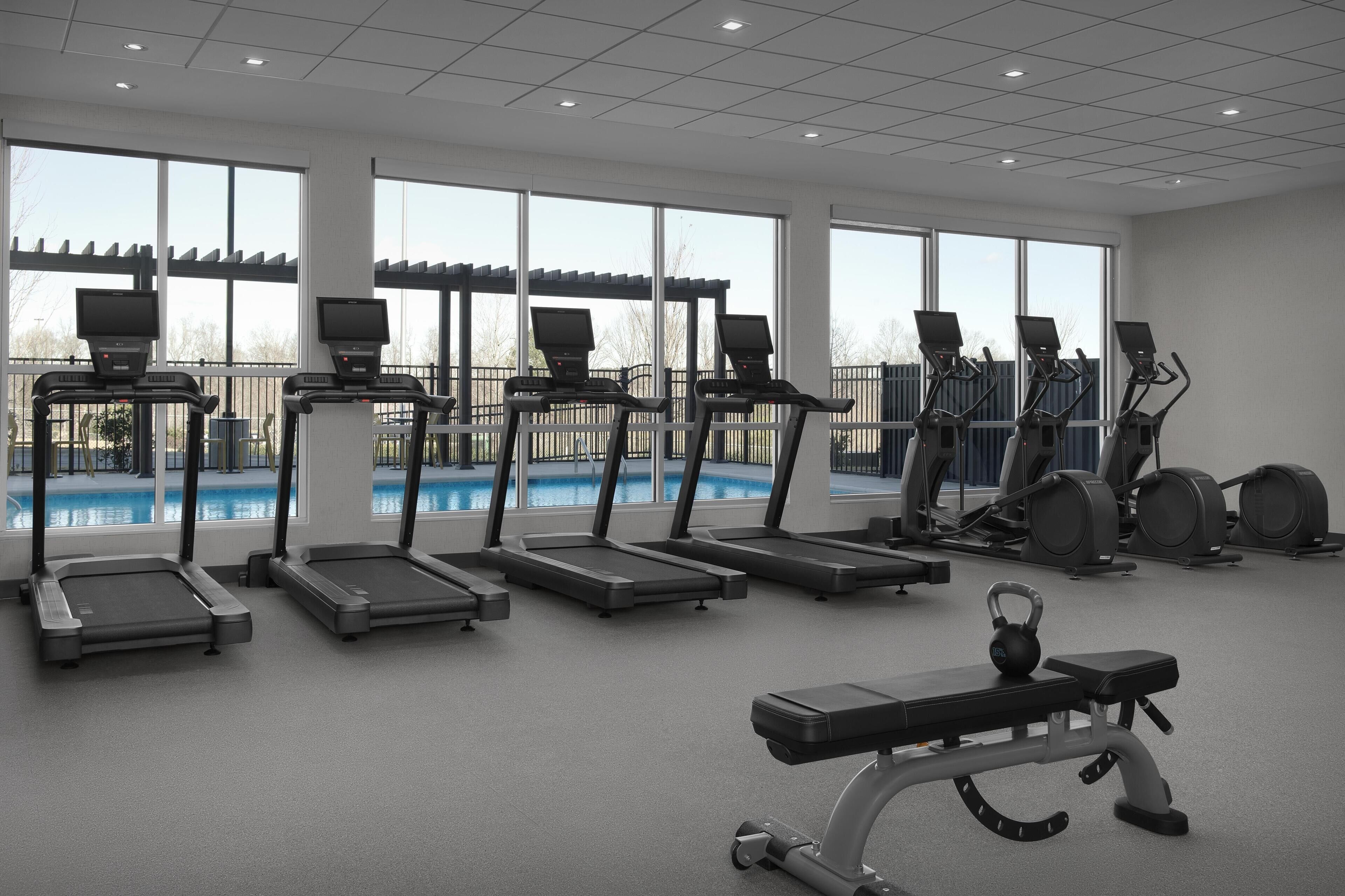 A gym with treadmills, a bench, and a kettlebell.
