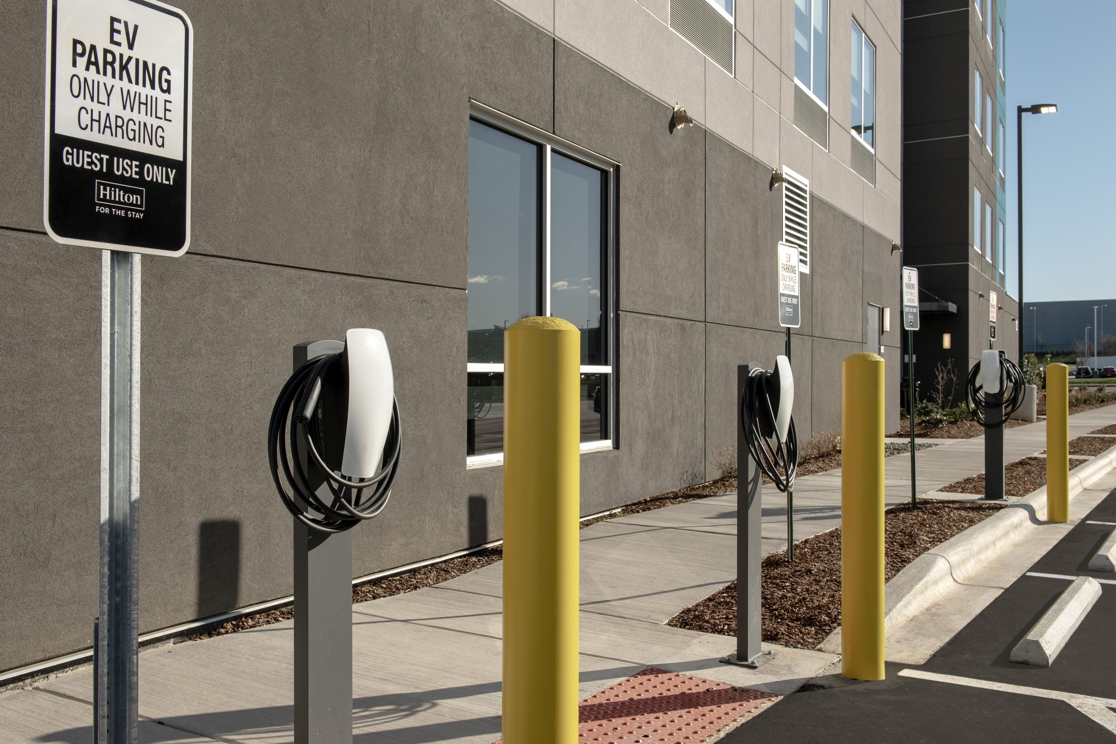 A modern building with EV charging stations and a sign indicating guest use only.