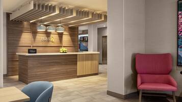 A hotel reception area with a wooden reception desk, a blue chair, and a red chair.