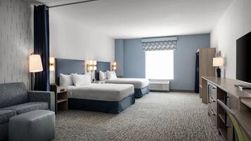 Ein Hotelzimmer mit einem Bett, zwei Nachttischen, einem Schreibtisch, einem Stuhl und einem Fernseher.