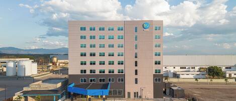 A multi-story building with a parking lot in front.