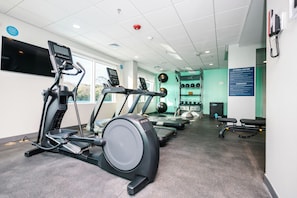 A fitness center with treadmills, exercise balls, and a wall-mounted television. - Tru By Hilton Distrito Palmerola (Comayagua)