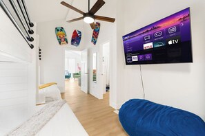 A modern living room with a flat-screen TV mounted on the wall displaying various streaming services. - Heated Pool Steps to Beach, Cherry Grove Sleeps 24 (North Myrtle Beach)