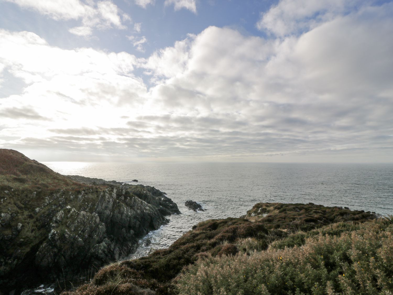 A coastal landscape with rocky terrain and vegetation.