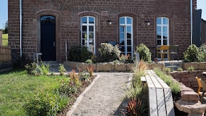 A two-story brick house with a symmetrical facade, multiple windows, and a front door.