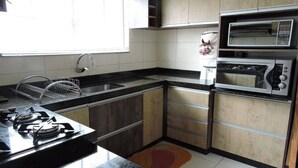 A kitchen with a gas stove, double sink, and two ovens. - Your Refuge in Bombinhas – Airy family home close to the beach (Bombinhas)