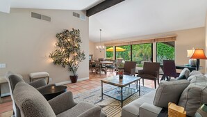 Un salon spacieux doté d’une grande fenêtre, d’un coin repas et d’un espace salon confortable.