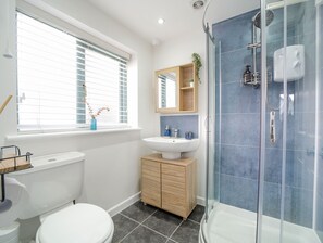 Een douche, handdoeken, zeep, toiletpapier