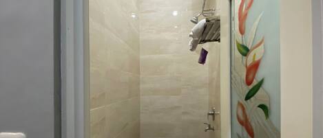 A small, modern bathroom with a toilet, sink, and shower.