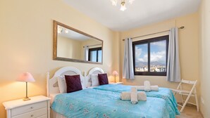 A bedroom with two beds, a dresser, a mirror, and a window with a view. - Marina Real Port View 2457 (Manilva)