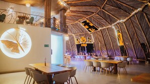 An interior with a thatched roof, wooden tables, and chairs. - Samay Playas (Playas)