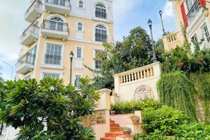 A multi-story building with balconies, a staircase, and lush greenery. - Moonlight Hotel Phu Quoc (Phu Quoc Island)