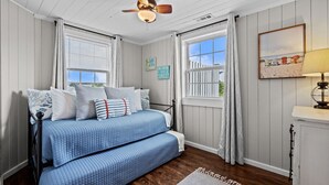 A bedroom with a bed, a ceiling fan, and a window with curtains. - Bright, Beachy, and So Close to the Sea (Atlantic Beach)