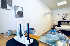 Une chambre d’hôtel moderne équipée d’un lit, d’une table de chevet et d’un ventilateur fixé au mur.