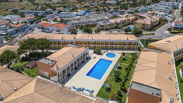 An aerial view of a residential area with a large swimming pool surrounded by buildings.