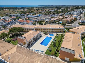 An aerial view of a residential area with a large swimming pool surrounded by buildings. - Pool & Beach in Encosta São José (Guia)