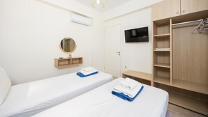 A hotel room with two beds, a TV, a wardrobe, and a mirror. - Villa Pinelopi Tria - Two Bedroom Villa, Sleeps 5 (Ionian Islands)