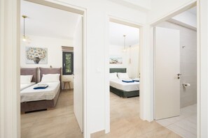 Habitación de hotel con dos camas, una mesita y una ventana con vista a zonas verdes.