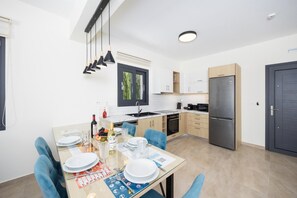 Una cocina moderna con comedor, equipada con refrigerador, estufa y una mesa de comedor para cuatro.