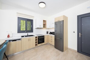 A modern kitchen with a dishwasher, oven, and refrigerator.