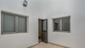 A corridor with two windows, a door, and a light fixture.