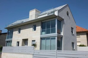 A modern two-story building with large windows and a flat roof. - Samil Dunes Apartments (Vigo)