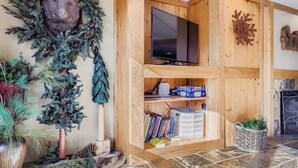 Ein gemütliches Wohnzimmer mit einem TV-Schrank aus Holz, einem Kamin und einem Bücherregal.