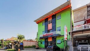 A multi-story building with a green facade, a balcony, and a sign that reads 'Hotel.' - RedDoorz near Ubud Village (Bali)