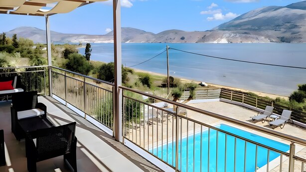Un balcón con piscina, mobiliario exterior y vistas al mar y a las montañas.