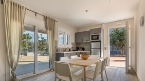 Una cocina moderna con comedor, ventanas amplias y vistas al exterior.