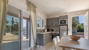 Una cocina moderna con comedor, ventanas amplias y vista a la playa.