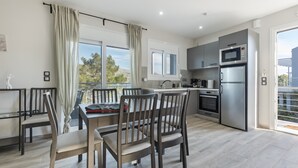 Una cocina moderna con comedor, ventanas amplias y vistas al exterior.