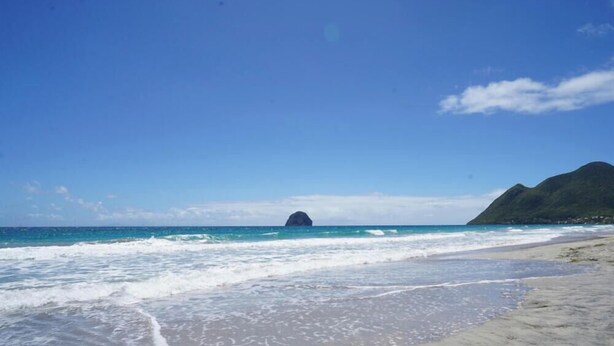 A beach with waves, a clear sky, and a mountain in the background. - Villa Mandarine - Two Bedroom Villa, Sleeps 4 (Le Diamant)