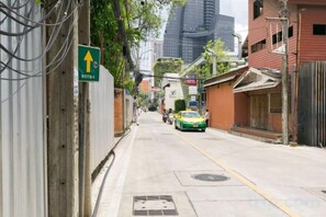 A street with buildings, a green directional sign, and a yellow taxi.