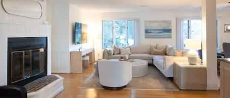 Uma sala de estar moderna com lareira, sofá em formato de L e mesa de centro.
