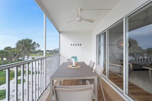 A balcony with a table, chairs, a ceiling fan, and a view of the beach. - Captiva Beachfront Front Condo| Heated Pool| Golf Cart (Captiva Island)