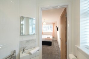 Een moderne badkamer met een grote spiegel, een wastafel en een toilet.