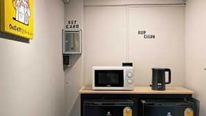 Angolo cottura attrezzato con forno a microonde, macchina del caffè, e un lettore di carte contrassegnato con 'BET CARD' e 'EUP CLEAN'.